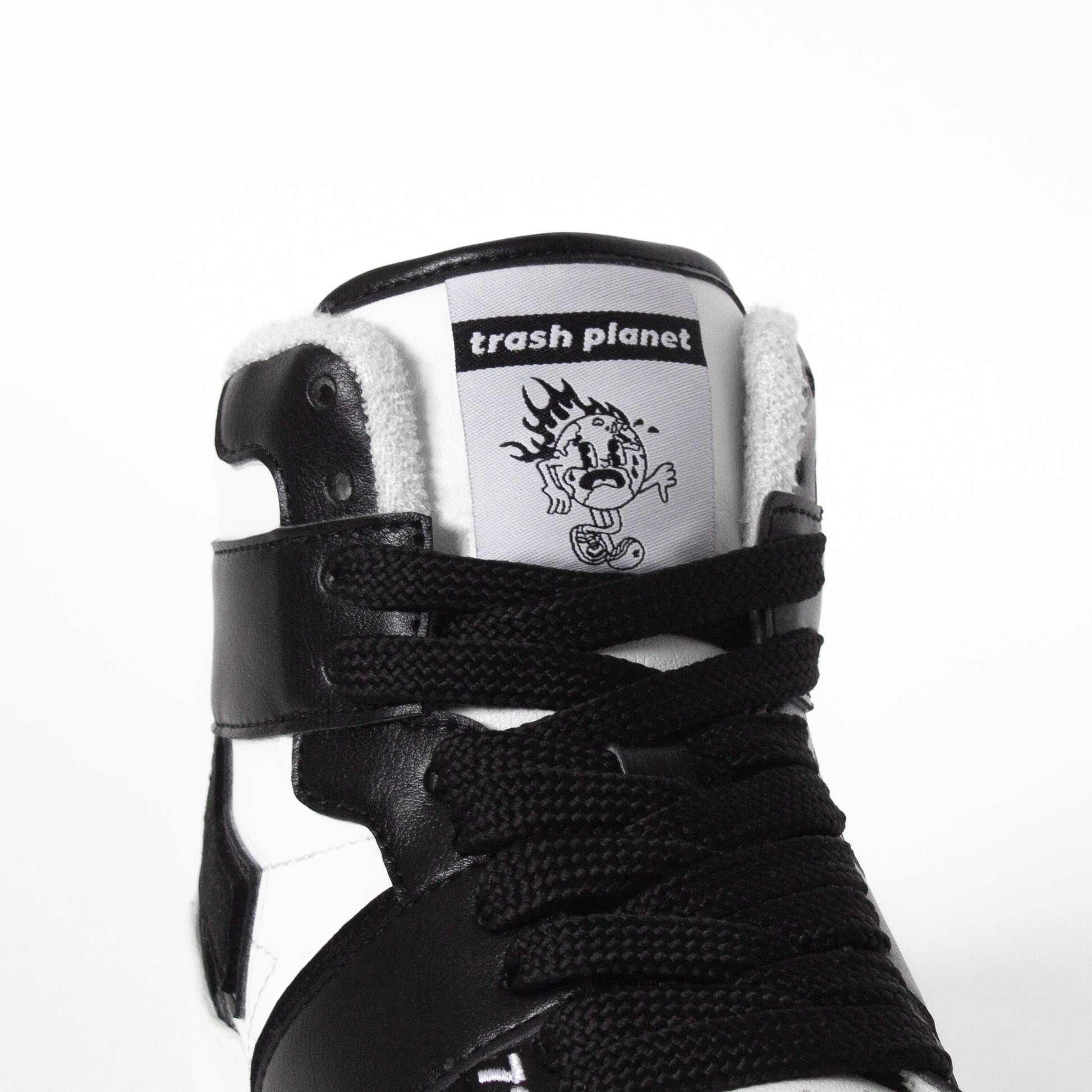 Earth on fire tongue detail on a black and white high top sneaker by Trash Planet