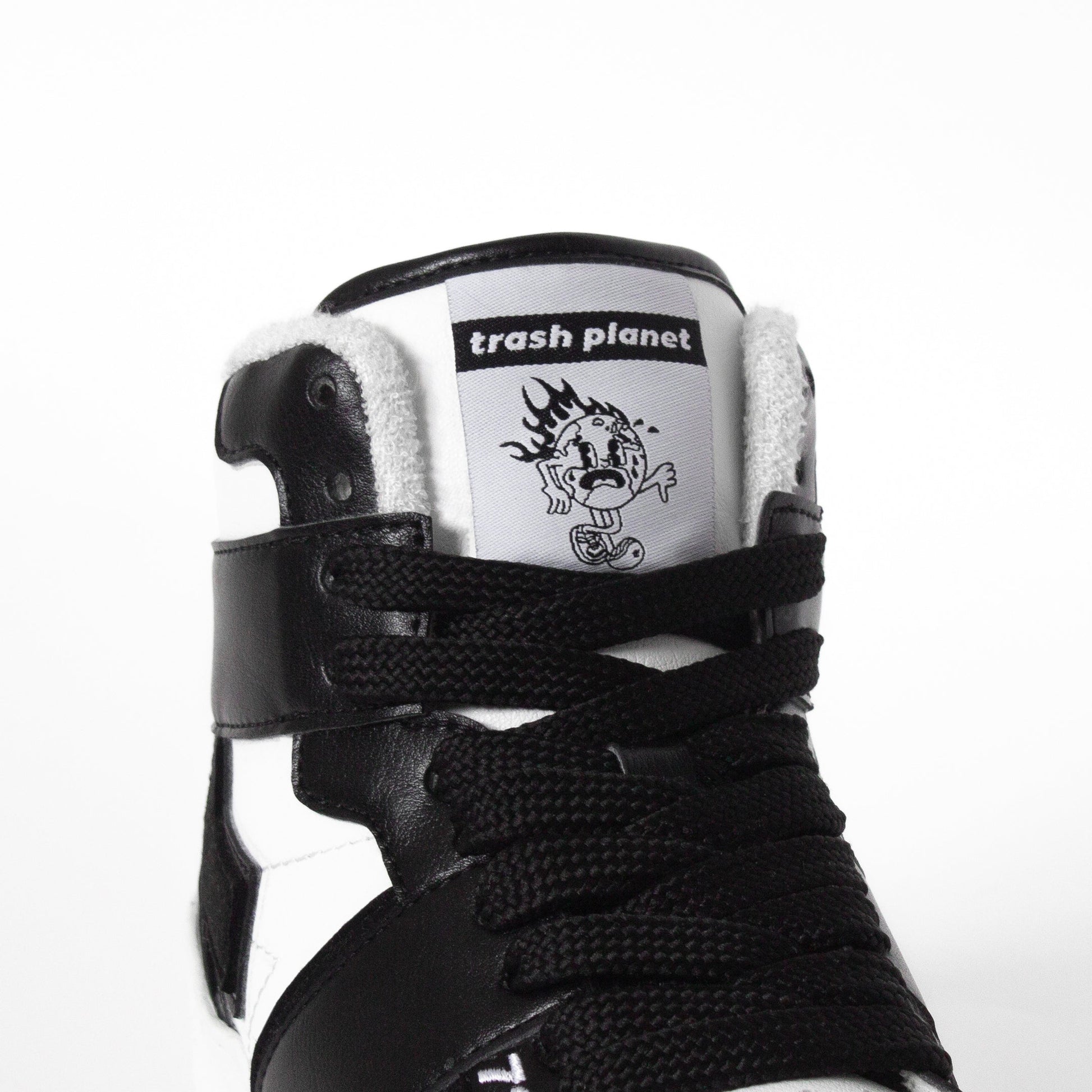 Earth on fire tongue detail on a black and white high top sneaker by Trash Planet 